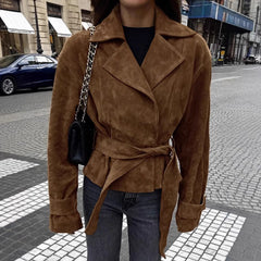 Person wearing a brown suede jacket on a city street