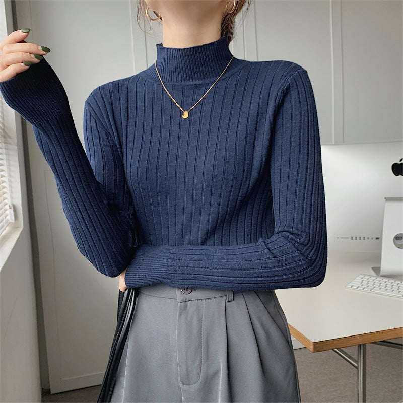 Person wearing a blue ribbed sweater in an indoor setting